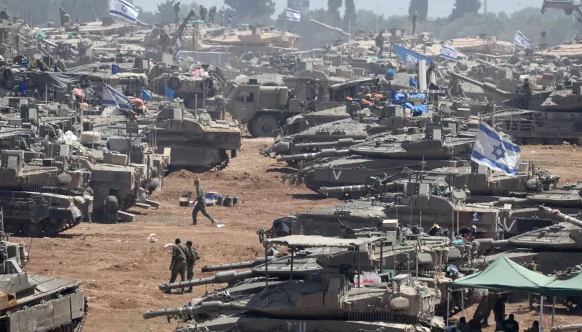 Soldados israelíes junto a sus vehículos militares se reúnen en Gaza.
