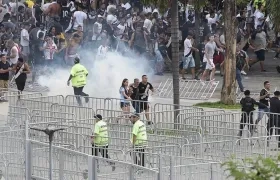 Aficionados corren despavoridos en medio de los disturbios.