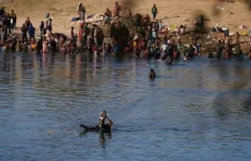 Un migrante cruza el río Bravo entre Estados Unidos y México, cerca de Del Río, Texas.