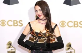 Olivia Rodrigo posando con sus tres Grammys.