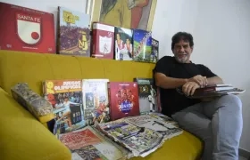 Jairo De la Rosa y parte de la colección de libros y revistas que conserva en su residencia.