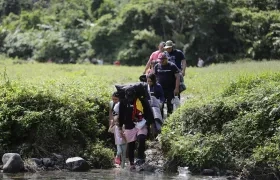  Migrantes acompañados con niños pequeños mientras caminan el Darién