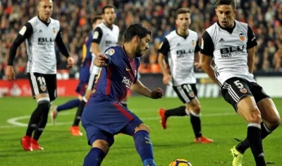 Luis Suárez enfrenta a la defensa del Valencia. 