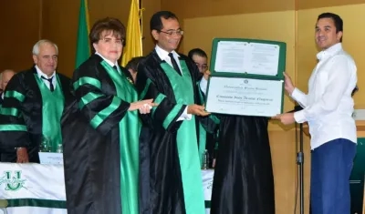 Andrés Molina recibe de manos del rector José Consuegra Bolívar el título póstumo Honoris Causa en Sociedad y Cultura Caribe para su mamá Consuelo Araújo. 