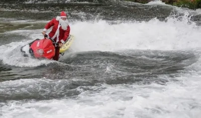 Momento en que el hombre disfrazado de Papá Noel aparece en una moto acuática.