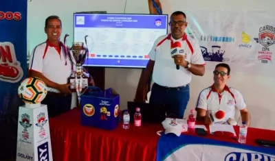 Carlos Bolívar (izquierda), director del torneo, sostiene el trofeo.