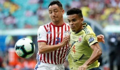 El jugador de Colombia Luis Díaz disputa el balón con Ivan Piris de Paraguay.