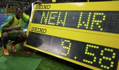 Usain Bolt festeja su récord en el tablero digital de la pista. 