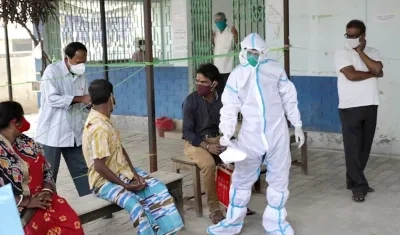 Varias personas esperan su turno para realizarse un test de coronavirus en un centro de salud de Calcuta, India. 
