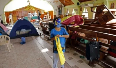 Un niño juega en una iglesia usada como albergue.