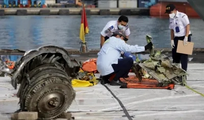Investigadores con algunas partes del avión accidentado en Indonesia.