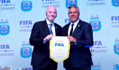 Gianni Infantino entrega un banderín de la FIFA al presidente de la AFA, Claudio Tapia, durante su visita a Argentina.