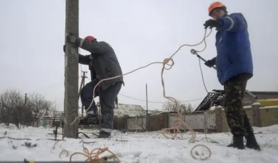 Imagen de archivo de dos operarios trabajando en el tendido eléctrico de la ciudad de Avdiivka, Ucrania.