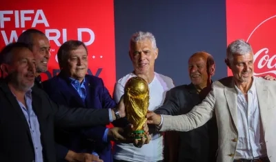 Los exfutbolistas argentinos Carlos Tapia, Sergio Batista, Daniel Bertoni, Alberto Tarantini, Omar Larrosa y Sergio Giusti posan junto al trofeo de la Copa Mundial.