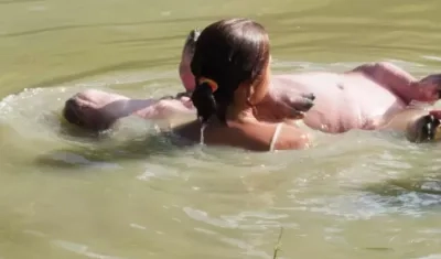 Menor nadando con un hipopótamo.