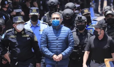 Policías custodian al expresidente hondureño Juan Orlando Hernández (c) rumbo a su extradición.