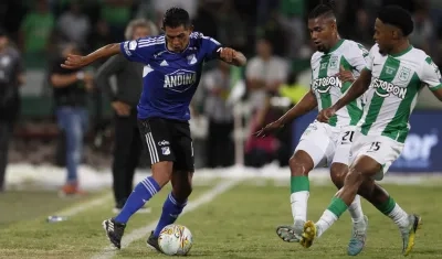 David Macalister Silva encara dos rivales de Nacional durante el partido en Medellín. 