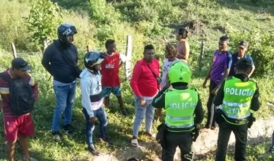Personas observan el cuerpo del motociclista en el lugar del accidente. 