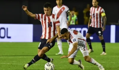 El paraguayo Andrés Cubas disputa el balón con el peruano Yoshimar Yotún.