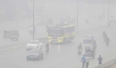 Personas viajan en automóviles y motocicletas bajo una nube de contaminación en Lahore (Pakistán)