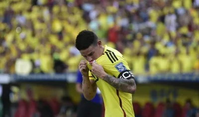James Rodríguez besando el escudo de la selección Colombia.
