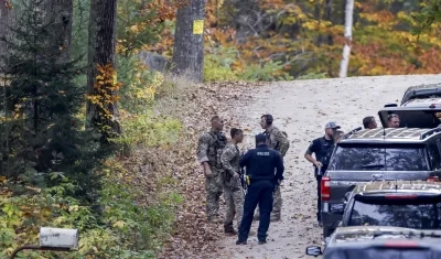 Miembros de la policía buscaban ayer al sospechoso de los tiroteos masivos en Lewiston, Maine.
