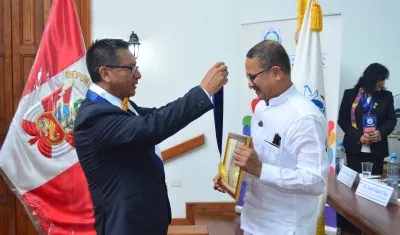 Jaime Fernández, secretario general de la Federación para la Paz Universal, le impone a Fausto Pérez la medalla.