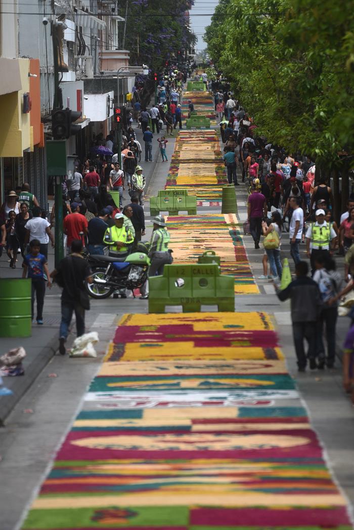  Voluntarios guatemaltecos participan en la elaboración de una alfombra de serrín.