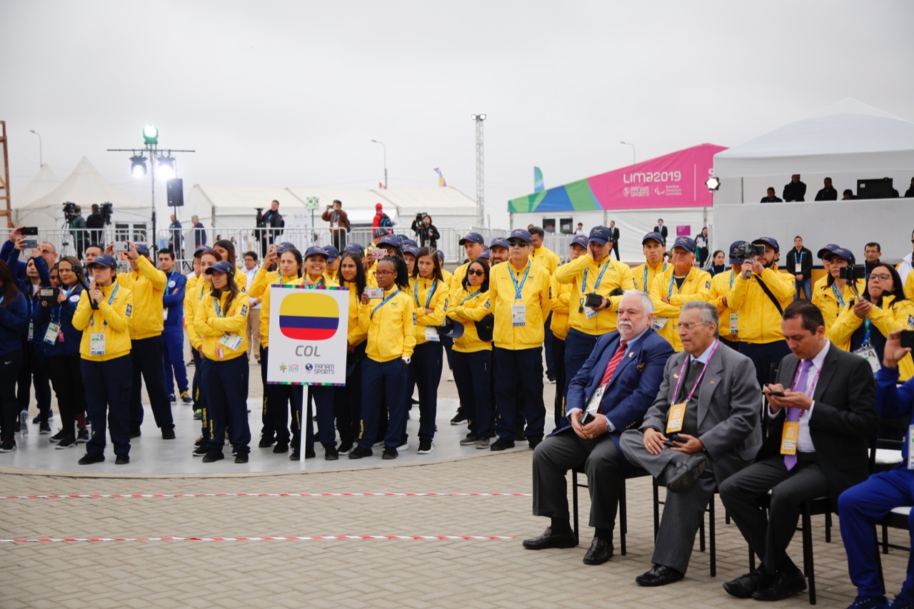 La delegación de Colombia espera mientras se iza la bandera.