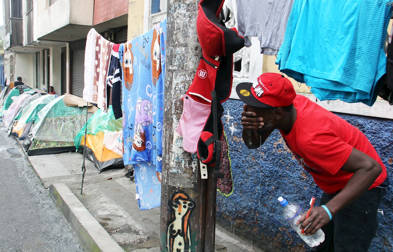 Un migrante haitiano en ruta hacia Norteamérica se lava la cara en Pasto.