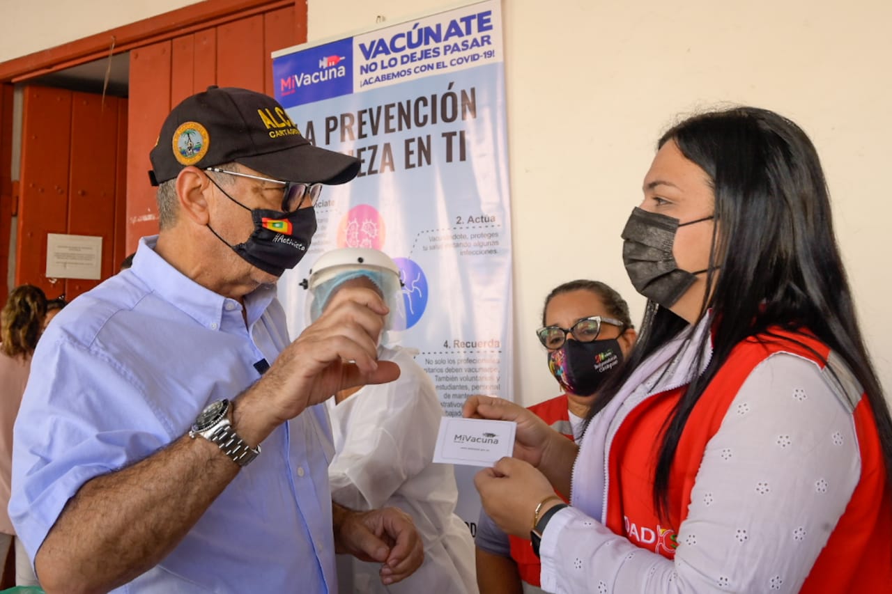 El alcalde de Cartagena, William Dau, recibe el carnet de vacunación de Johana Bueno, la directora del Dadis.