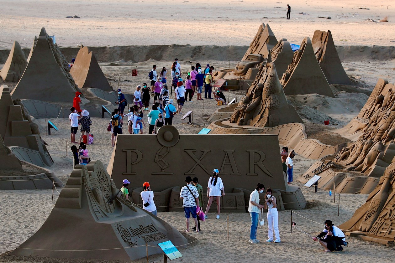 Varias personas se acercan a la exposición de esculturas de arena basadas en las películas de Pixar en Nueva Ciudad de Taipei en Taiwán.