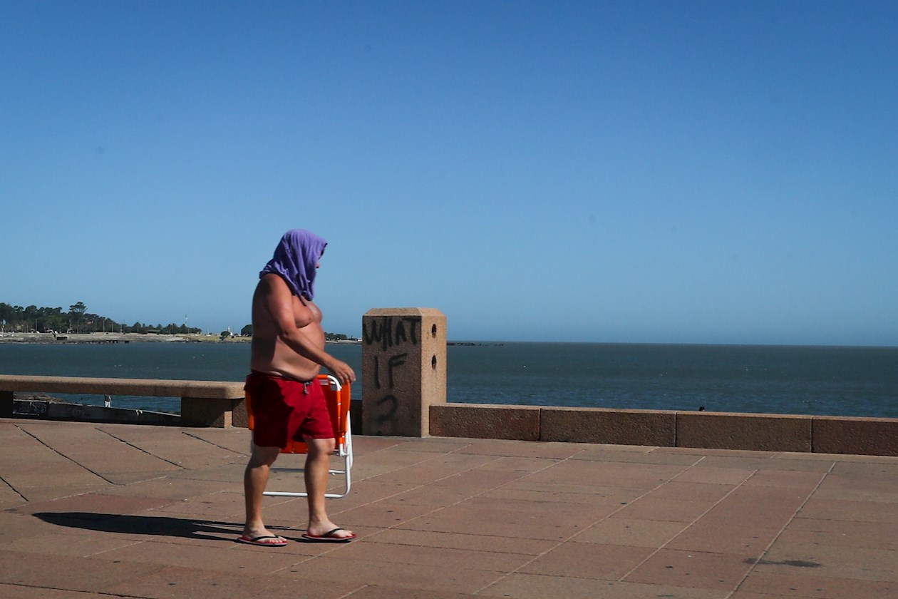  Un hombre camina por la rambla de Montevideo este jueves, durante la ola de calor que rige desde el pasado martes y se extenderá hasta el próximo domingo. 