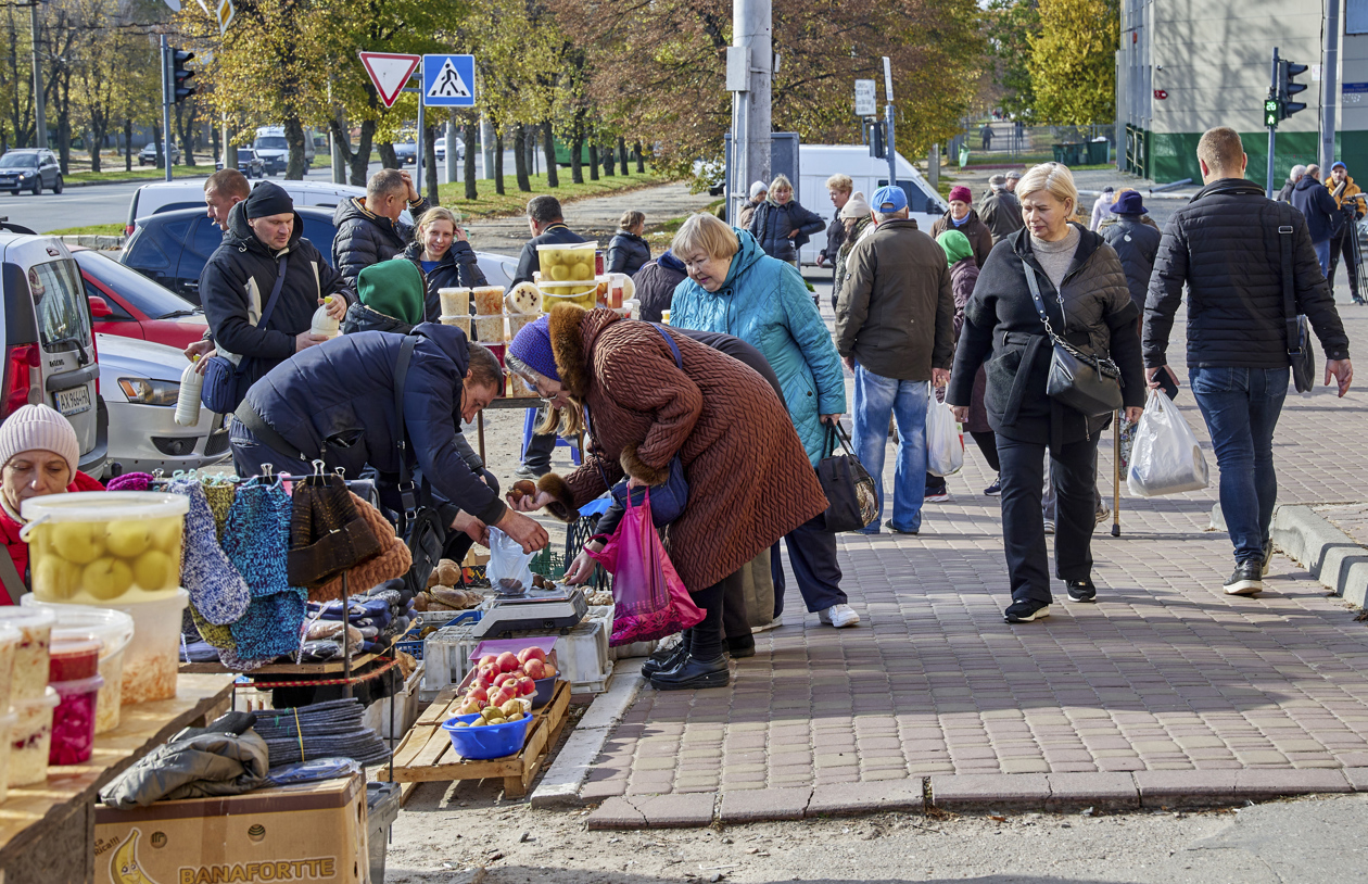 Lugareños hacen compras en un mercado callejero en Kharkiv, Ucrania.