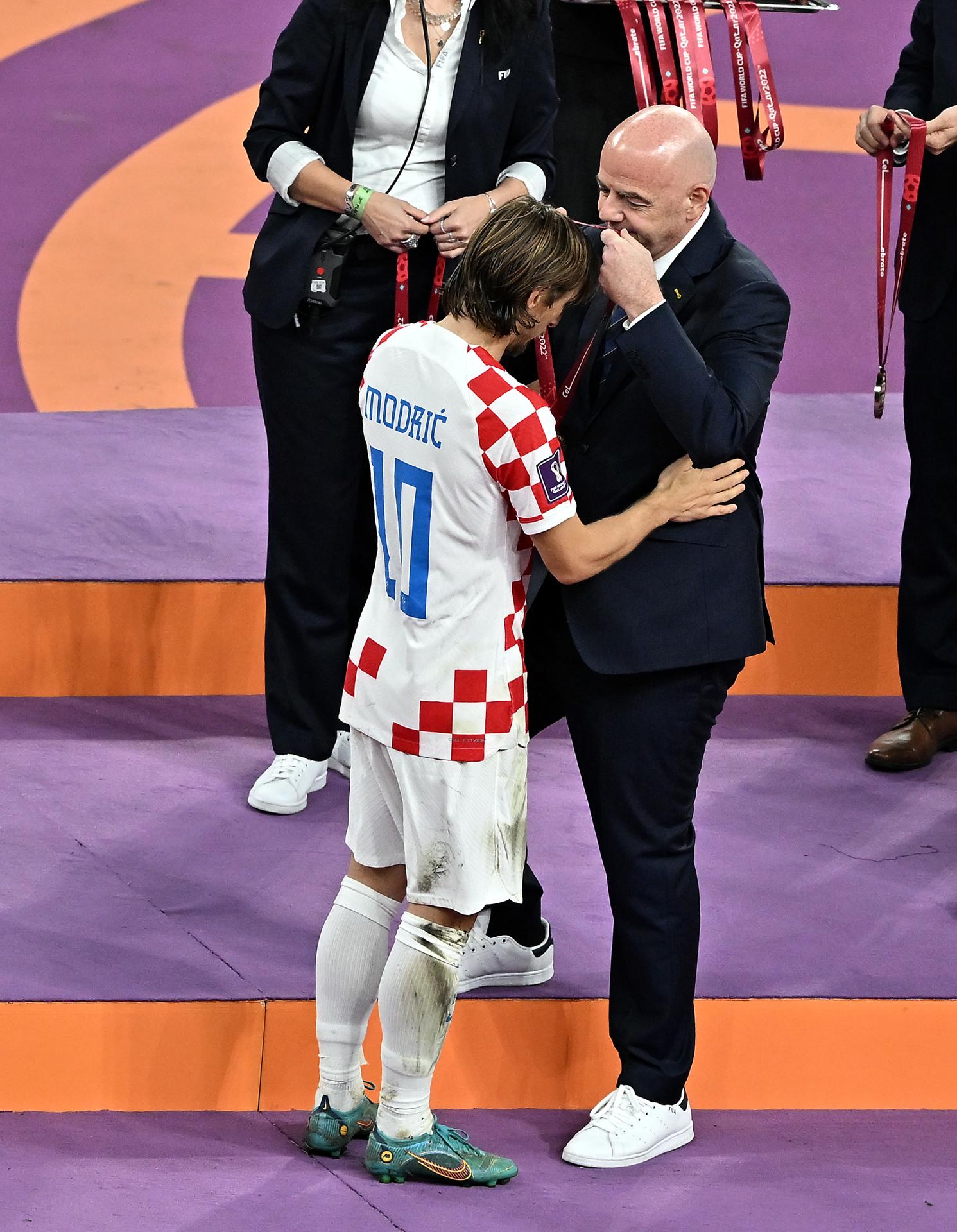 Luka Modric recibe su medalla de bronce de manos del presidente de la FIFA, GIanni Infantino