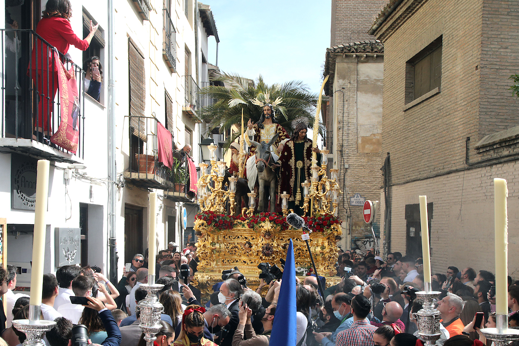 Una mujer canta una saeta ante el paso de la Borriquilla durante la procesión del Domingo de Ramos en Granada, España.