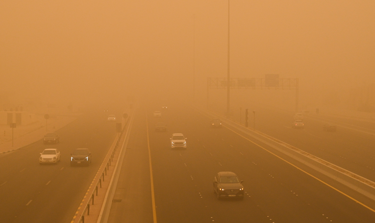Los automóviles circulan en medio de una fuerte tormenta de polvo en la ciudad de Kuwait.