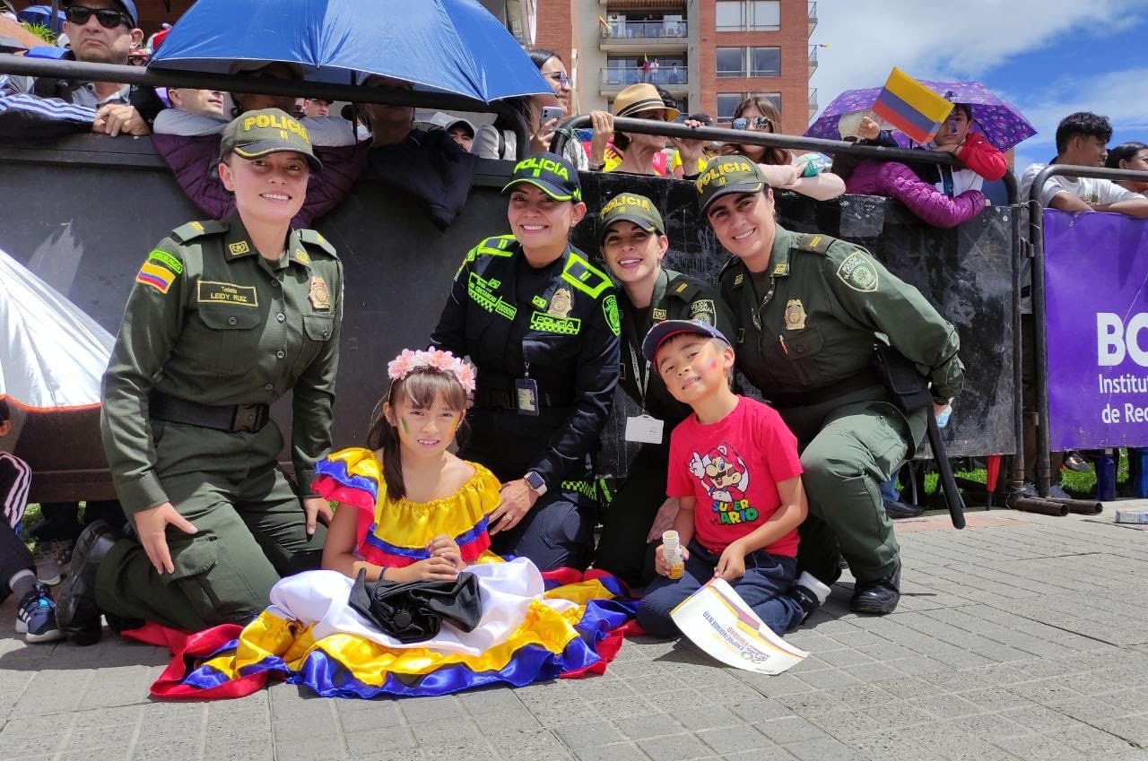 Policías posan junto a niños en el desfile en Bogotá.