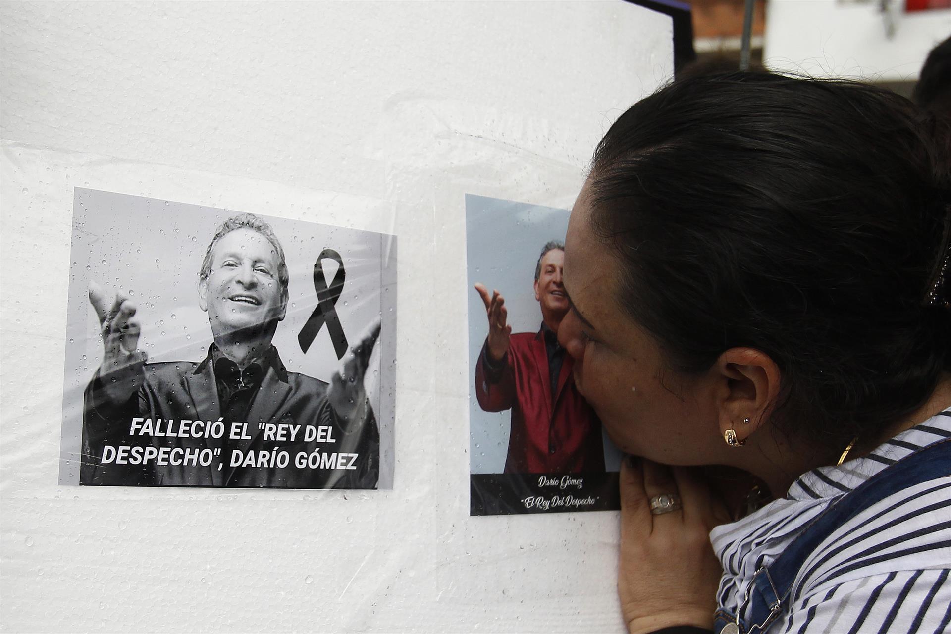 Una mujer estampa un beso sobre la foto de su ídolo Darío Gómez.