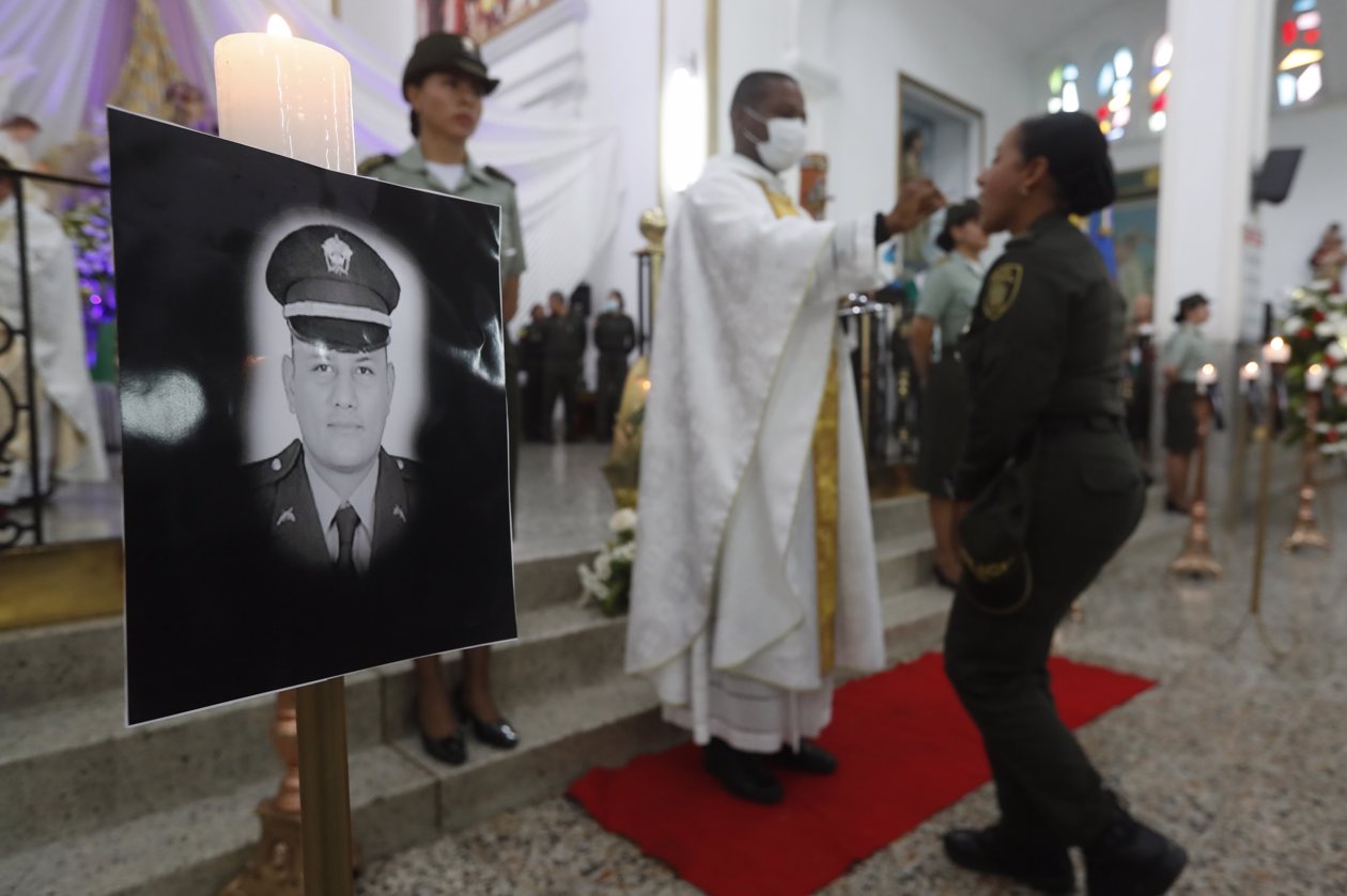 Vista de retratos durante ceremonia religiosa en honor a los policías asesinados recientemente en el país por el 'Clan del Golfo', en Cali.
