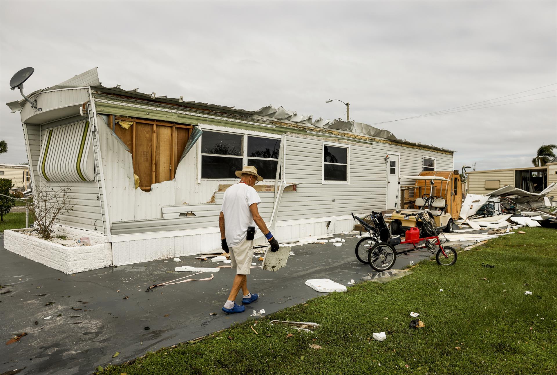 Un hombre pasa por una vivienda destruida por el huracán en Fort Myers.