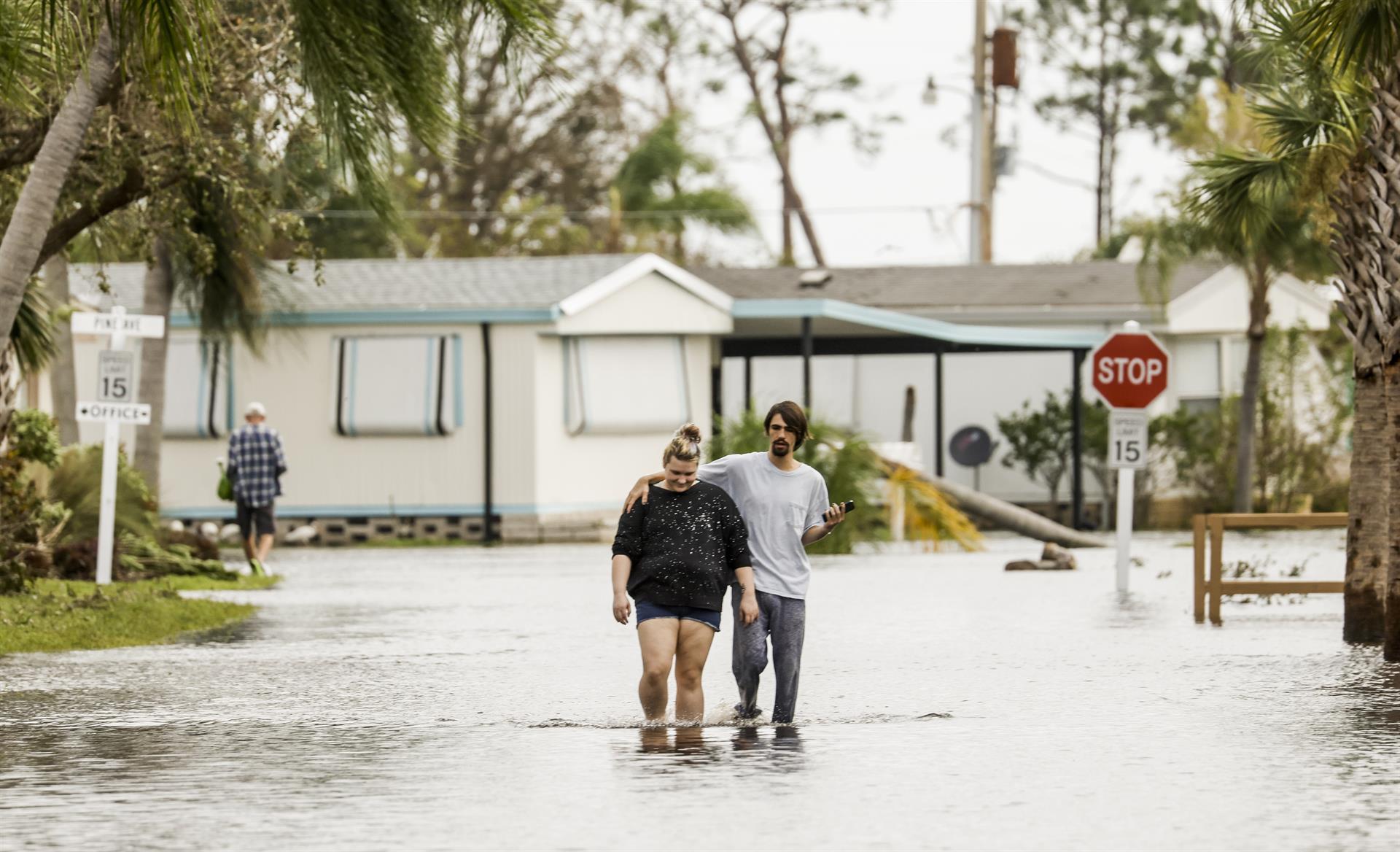 Una pareja camina entre sectores totalmente inundados en el Estado de Florida.