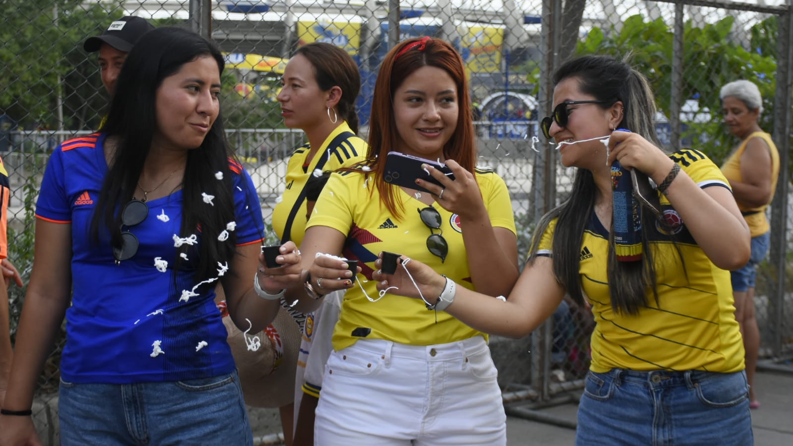 Tres mujeres intentando tomarse una foto con la camisa de la selección.