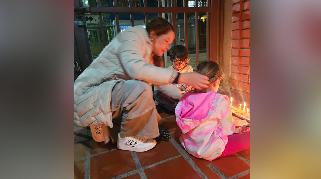 La barranquillera Jennifer De la Rosa con sus hijas encendiendo las velitas en Bogotá. 