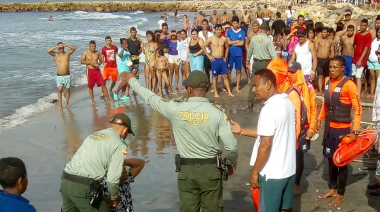 Un policía consuela a un familiar de la joven ahogada en Sabanilla.