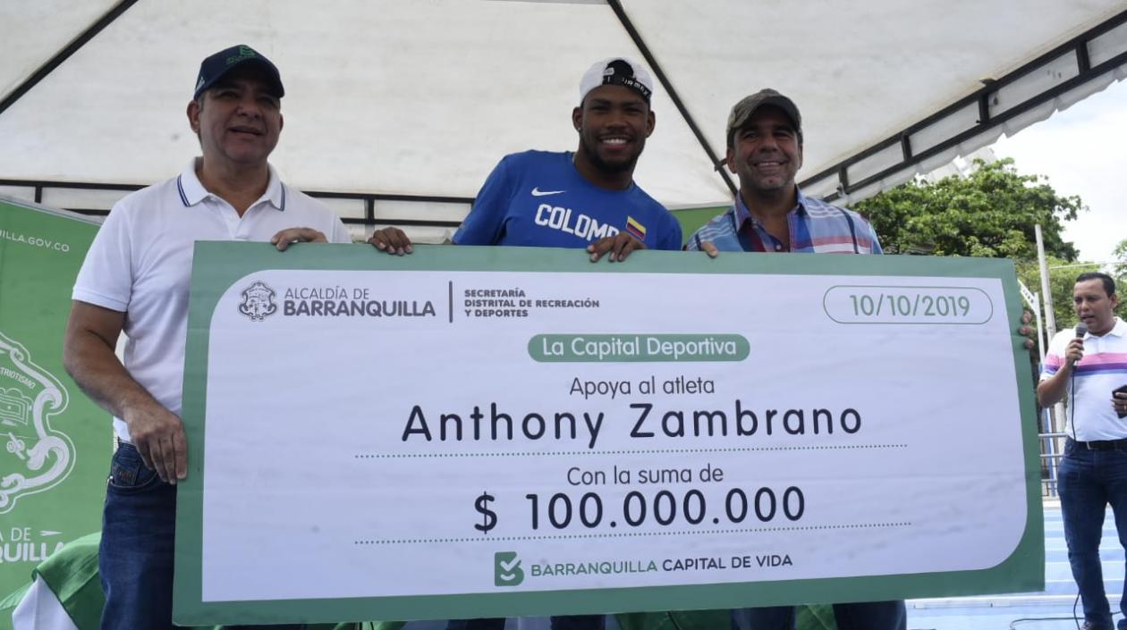 El atleta Anthony Zambrano recibió un cheque de 100 millones de pesos, lo acompaña José Luis Álvarez, secretario de Deportes.