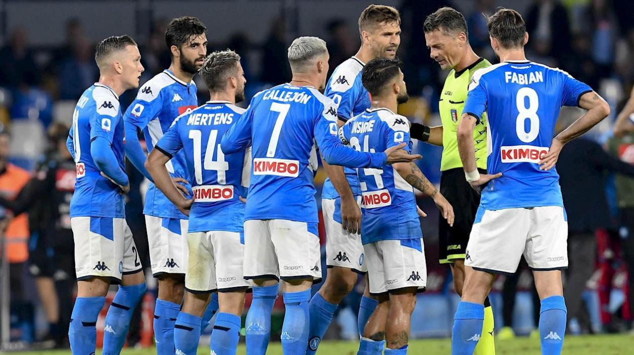 Jugadores del Nápoles protestan las determinaciones del árbitro. 