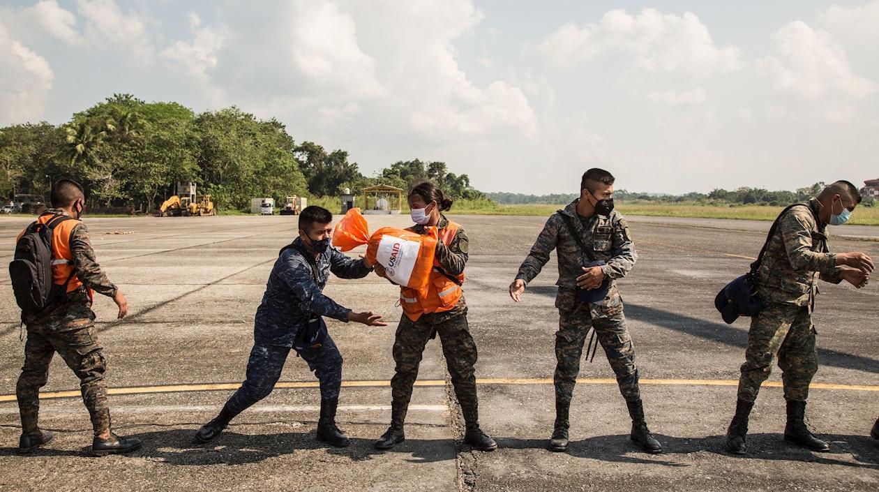 Miembros del ejército de Guatemala descargan los víveres y ayuda humanitaria transportados por el ejército de EE. UU.