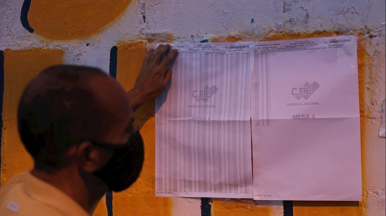 Un hombre identifica su lugar de votación hoy, en un centro de votación en Caracas (Venezuela). 
