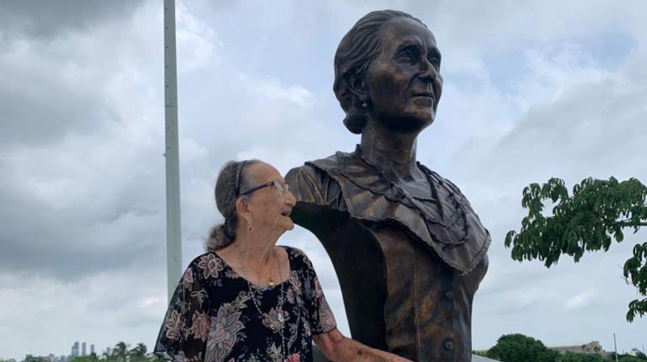 Carmen Mejía al lado de la estatua de Micaela la Valle.